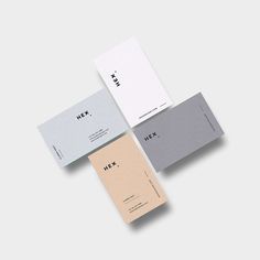 three different colored business cards sitting next to each other on top of a white surface