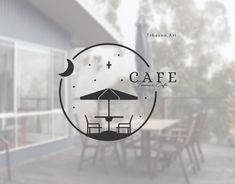 the logo for cafe with an umbrella and table in front of glass doors that look out onto trees