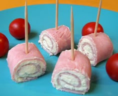 some food is on a blue plate with tomatoes and toothpicks in the background