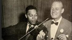 two men in tuxedos playing violin together