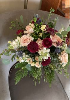 a vase filled with lots of flowers on top of a table