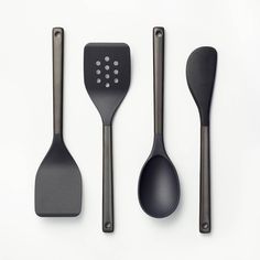 three black utensils and spoons on a white surface