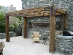 an outdoor living area with stone walls and wooden pergolated structures, including a covered seating area