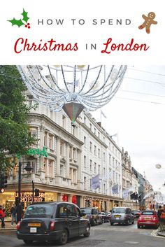 cars driving down the street in london with christmas decorations hanging over it and people walking on the sidewalk