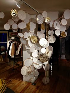 a room filled with lots of white plates hanging from the ceiling next to a wooden floor