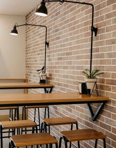 tables and stools are lined up against the brick wall