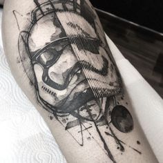 a black and white photo of a man's leg with a star wars tattoo on it