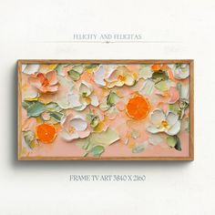 an orange and white flowered painting hanging on a wall next to a wooden frame