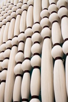 many white and brown wooden objects are arranged in a row on the wall, with one person standing next to it