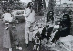 three young men standing next to each other in front of a car