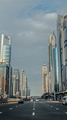 an empty city street with tall buildings in the background