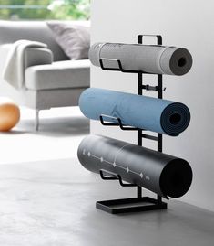 there are three yoga mats on the stand next to each other in this living room