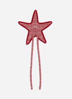 a red and white star ornament hanging on a wall