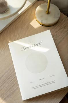 a close up of a piece of paper on a table with a lamp in the background