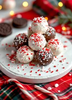 white chocolate covered cookies on a plate with sprinkles and candy canes