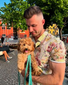 a man holding a small dog on a leash