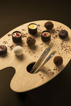 an artist's palette with chocolates on it and paintbrush in the middle