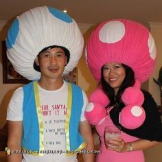 a man and woman in costumes standing next to each other with large objects on their heads