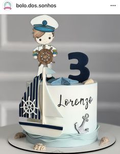 a birthday cake with a sailor on top and the number three in the middle is made out of fondant