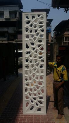 a man standing next to a tall white sculpture