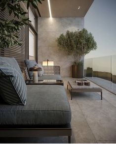 a living room filled with furniture next to a tall plant on top of a wooden table