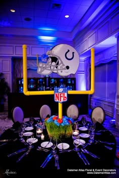 a football helmet on top of a table with plates and glasses in front of it