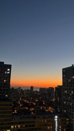 the city skyline is lit up at night, with skyscrapers in the foreground