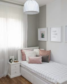 a white bed sitting in a bedroom next to a window