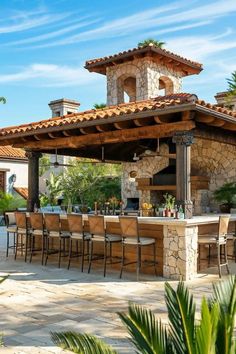 an outdoor kitchen with bar and grill area