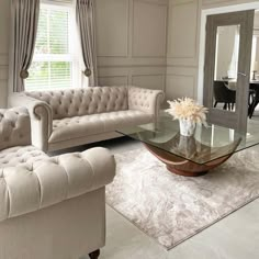 a living room filled with furniture and a glass top table in front of a mirror