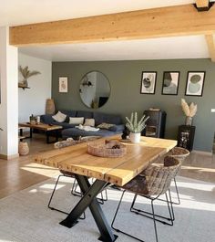 a living room filled with furniture and a wooden table in front of a mirror on the wall