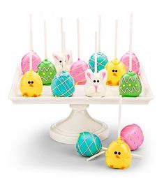 an assortment of decorated easter eggs on a cake plate