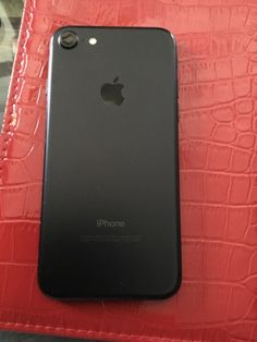 an iphone sitting on top of a red case