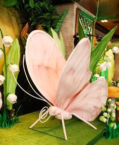 a pink butterfly sitting on top of a lush green field