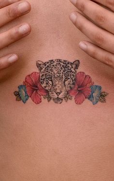 a woman's chest with a leopard and flowers tattoo on it