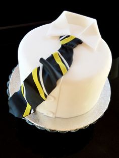 a white and black cake with a tie on it