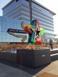 a tall building with a colorful star on it's side next to a sidewalk