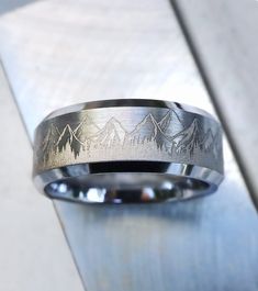 a wedding band with mountains engraved on it