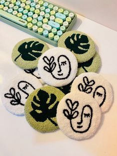 four green and white coasters sitting on top of a table next to a keyboard