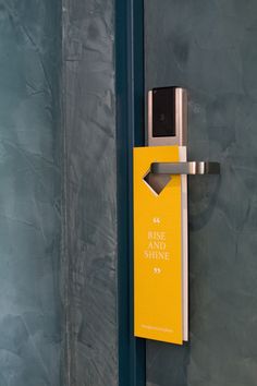 a door handle with a yellow sign attached to it that says, rise and shine