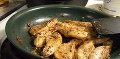 chicken being cooked in a pan on the stove