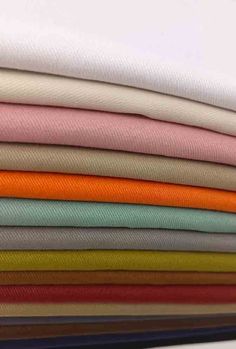 a stack of different colored fabrics sitting on top of each other