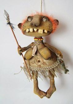 a stuffed animal with an orange hair holding a stick and wearing a feathered dress