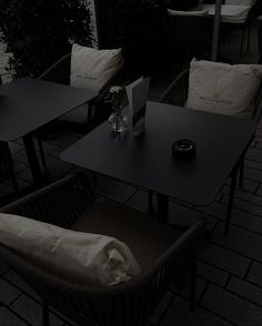 an empty table and chairs on a patio at night