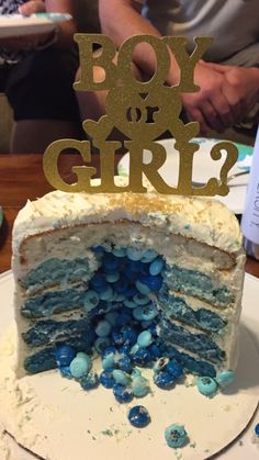 a blue and white cake with the word boy or girl cut out of it's side