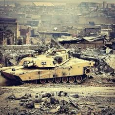 an old tank is sitting in the middle of a destroyed out area with other buildings behind it