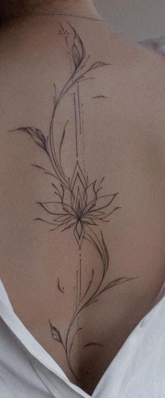 a woman's back with a tattoo design on her left side ribcage