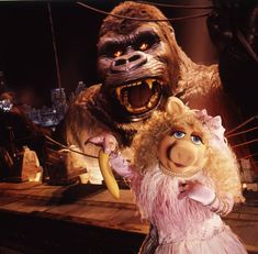 an image of a puppet with a monkey on it's head and a woman in a pink dress