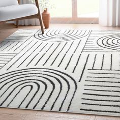 a white rug with black lines on it in front of a chair and window sill