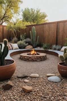 an outdoor fire pit surrounded by rocks and cacti